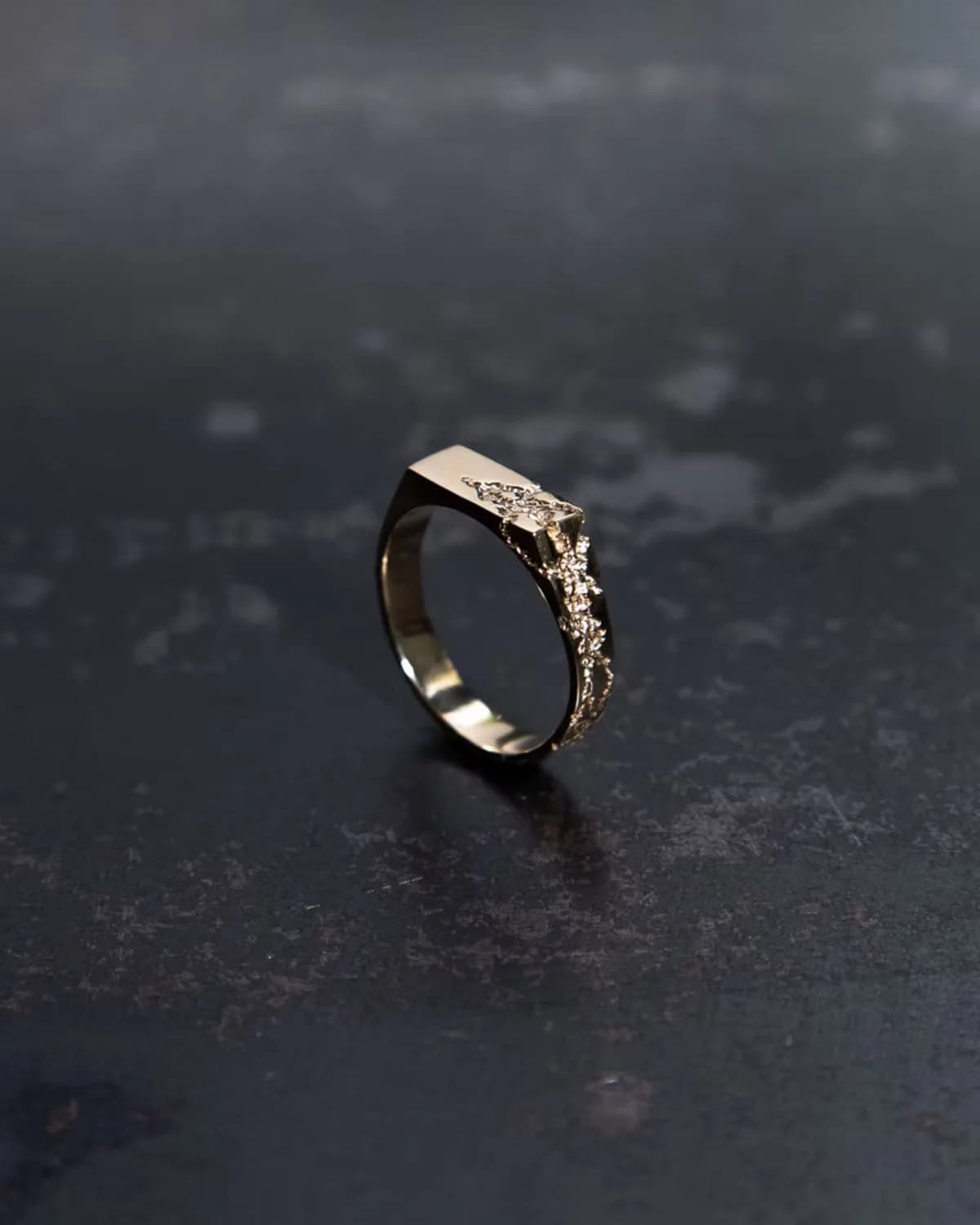 A gold ring with a rough organic surface