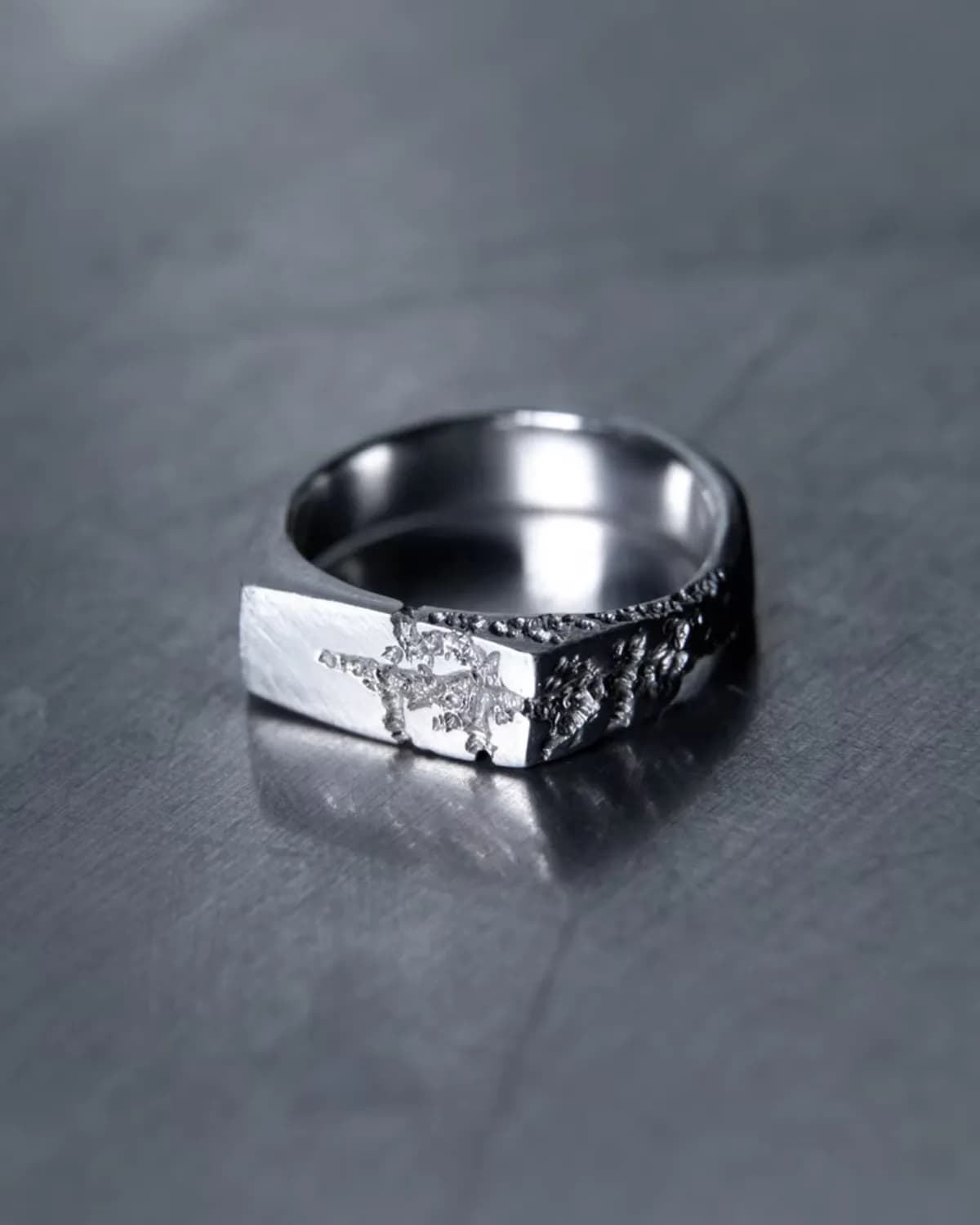 A dark silver signet ring with a hand-worked surface